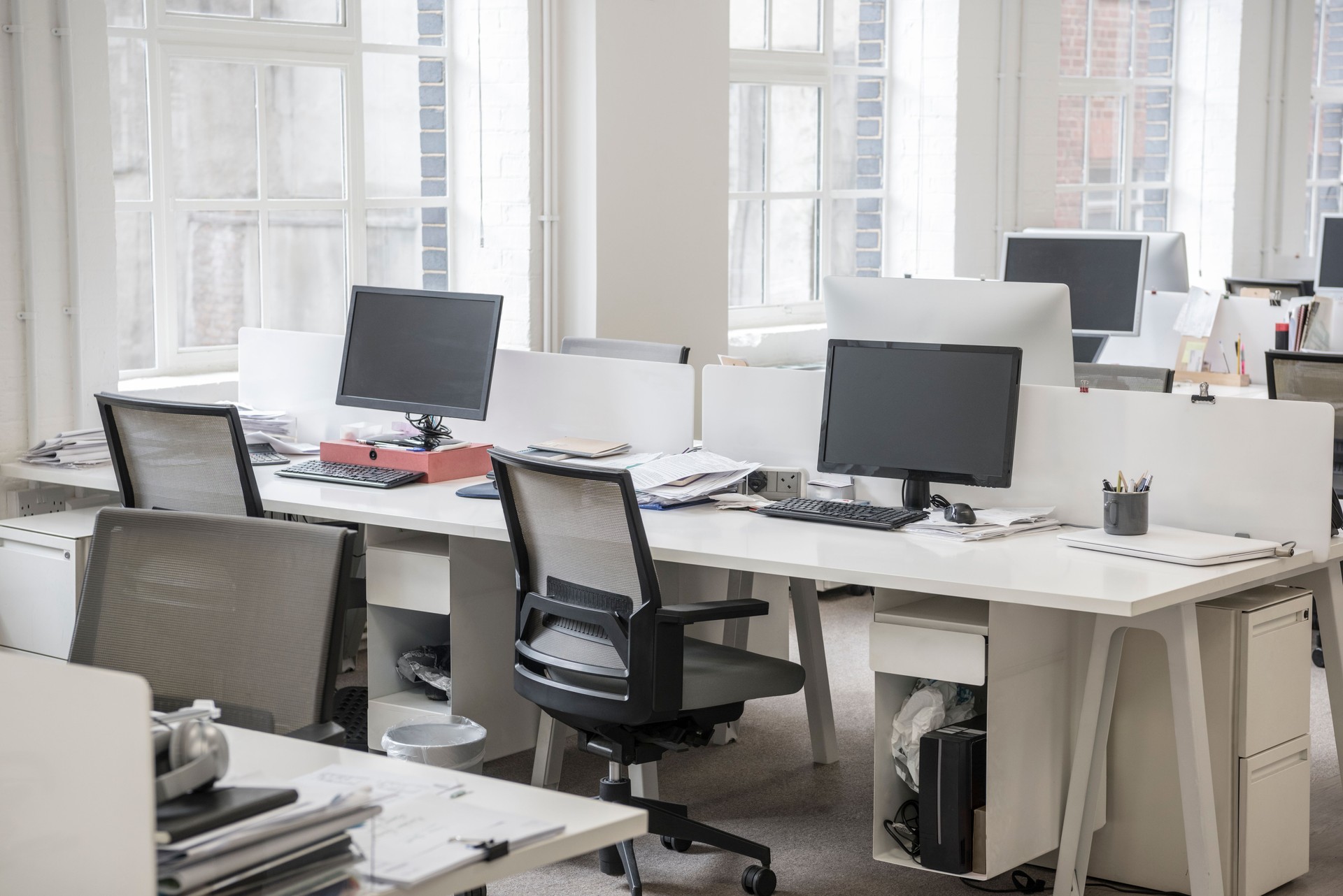 Work stations in office with empty office chairs and personal computers