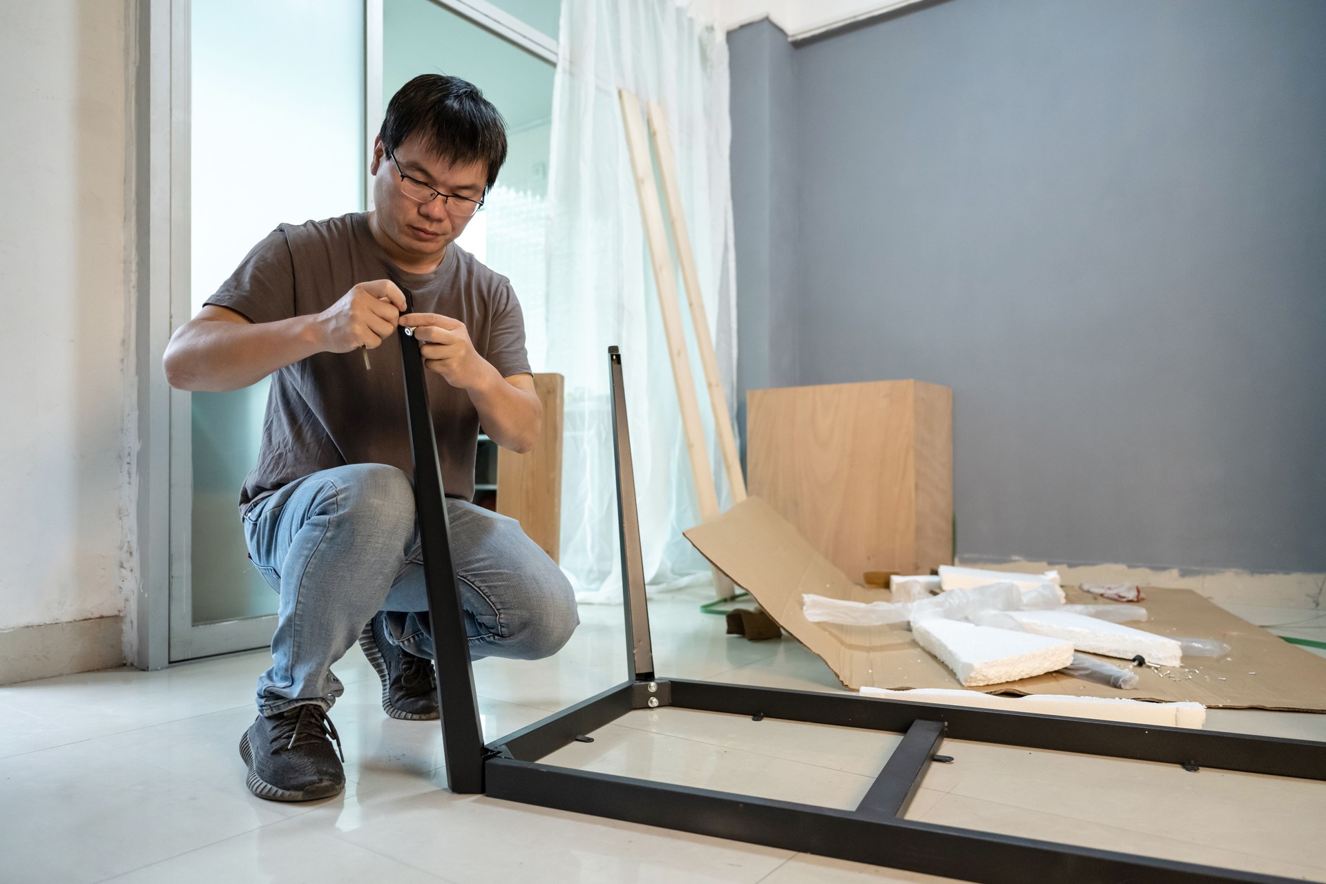 A man is installing furniture in the room